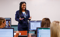 Professor talking to students in front of classroom